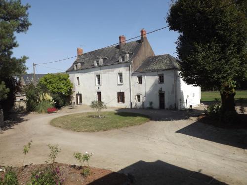 an old white house with a driveway in front of it at Manoir de L'Aisnerie in Saint-Herblain