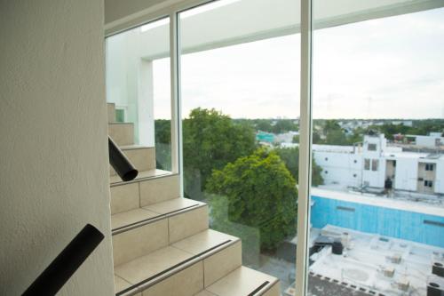 a room with a large window with a view of a building at Hotel Boutique Kinyaah in Mérida