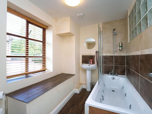 a bathroom with a tub and a sink at IRONBRIDGE - 18th CENTURY THREE BEDROOM COTTAGE - 6 BEDS in Ironbridge