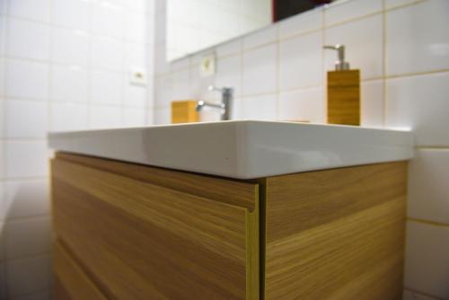 a bathroom with a white sink and a wooden cabinet at Bayonne en plein cœur Centre Historique 2 chambres in Bayonne
