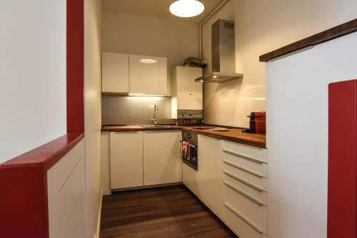 une cuisine avec des armoires blanches et un four à plaques de cuisson dans l'établissement Bayonne en plein cœur Centre Historique 2 chambres, à Bayonne