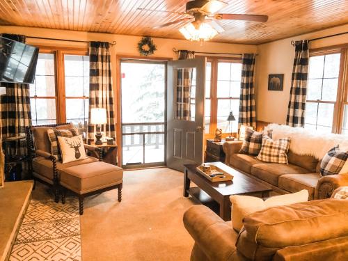 sala de estar con sofás, sofá y mesa en Riverfront Mountain Cottage Retreat en Estes Park