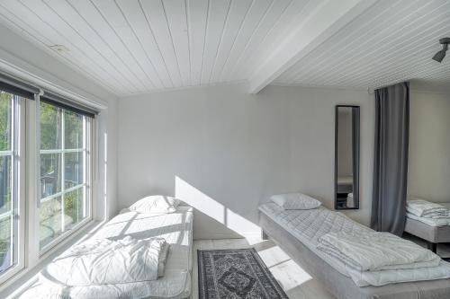 une chambre blanche avec un lit et une fenêtre dans l'établissement Lake cottage near Isaberg, à Åsenhöga