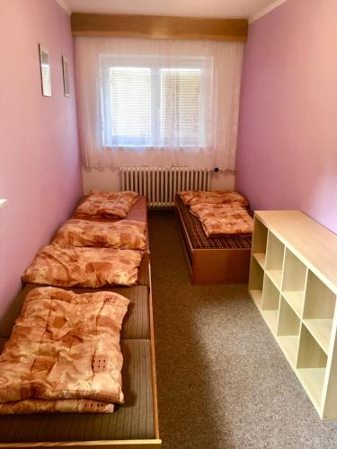 a room with three beds and a window at Chata Ostrá Ostravice in Ostravice