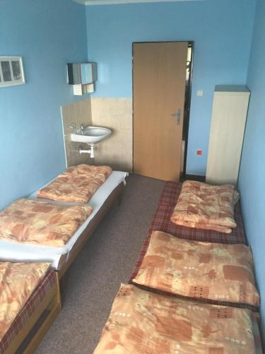 a room with three beds and a sink in it at Chata Ostrá Ostravice in Ostravice
