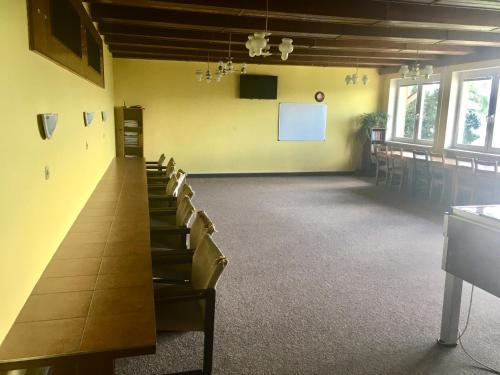 a room with a long table and chairs and a screen at Chata Ostrá Ostravice in Ostravice