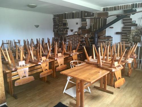 una fila de mesas y sillas de madera en una habitación en Chata Ostrá Ostravice en Ostravice