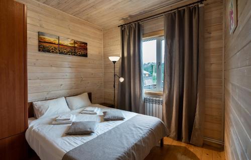 Dachniy Hotel Lesnyye Polyany في Mitino: غرفة نوم بسرير ابيض مع نافذة