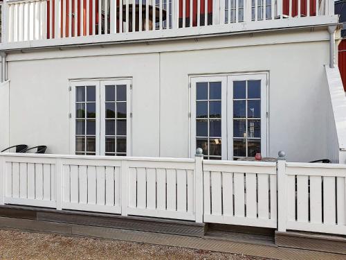 a white fence in front of a white house at 4 person holiday home in Gråsten in Gråsten