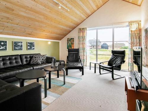 ein Wohnzimmer mit einem Sofa, Stühlen und einem TV in der Unterkunft 10 person holiday home in Bl vand in Blåvand