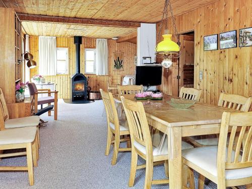 a dining room with a table and chairs and a fireplace at 4 person holiday home in Hvide Sande in Bjerregård