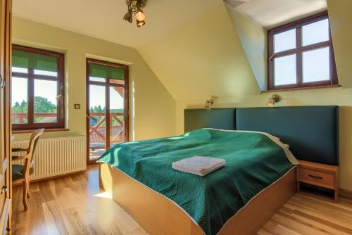 a bedroom with a bed with a green blanket at Jerzwałd 14 in Jerzwałd