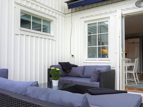 a patio with a purple couch and a table at Seaside Serenity in Mollosund-By Traum in Mollösund