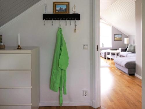 a green jacket hanging on a wall in a living room at Seaside Serenity in Mollosund-By Traum in Mollösund