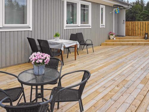 un patio con mesa y sillas en una terraza de madera en 6 person holiday home in HEN N, en Henån