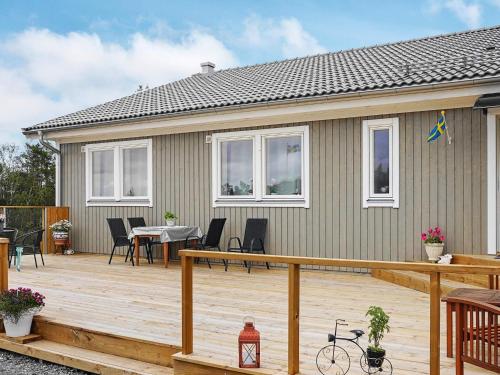 a house with a deck with a table and chairs at 6 person holiday home in HEN N in Henån