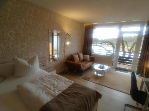 1 dormitorio con 1 cama, 1 silla y 1 ventana en Appartement Ausblick, en Hahnenklee-Bockswiese