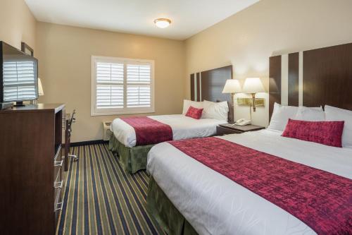 a hotel room with two beds and a television at Travel Inn Sunnyvale in Sunnyvale