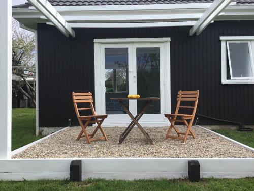 two chairs and a table in front of a house at Pa Road B&B Kerikeri NZ in Kerikeri