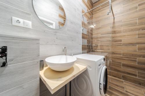 a bathroom with a sink and a washing machine at InshiApartments on Popovycha str 2 in Lviv