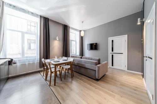 a living room with a couch and a table and chairs at InshiApartments on Popovycha str 2 in Lviv