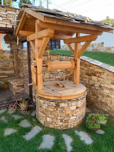 a wooden pergola sitting on top of a brick wall at Villa Detelina in Sapareva Banya
