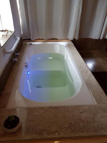 a bath tub sitting in a bathroom with at Colline Verte in Monte Verde