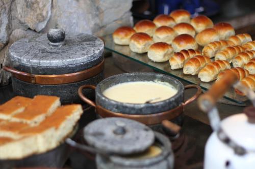 ein Buffet mit Speisen, Brot und Brötchen in der Unterkunft Pousada Relíquias do Tempo in Diamantina