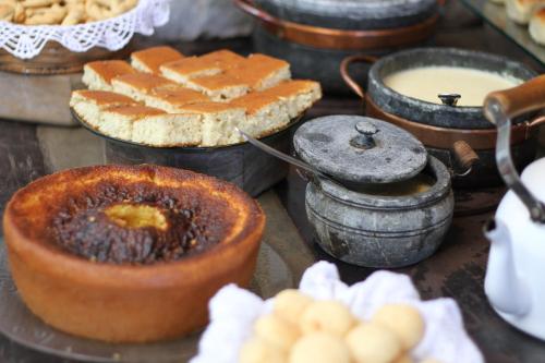 einen Tisch mit Kuchen und anderen Lebensmitteln in der Unterkunft Pousada Relíquias do Tempo in Diamantina