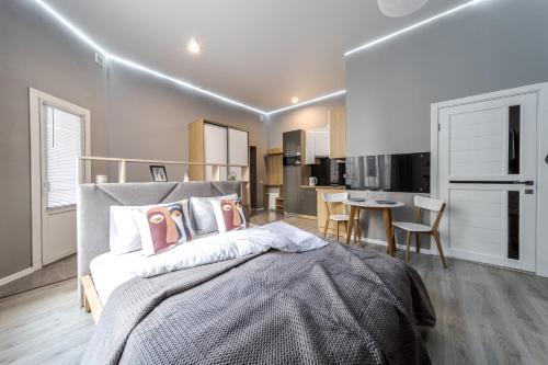 a bedroom with a large bed and a dining area at InshiApartments on Popovycha str 3 in Lviv