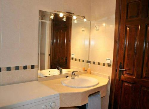 baño con lavabo y espejo grande en Serrania - Apartamentos El Cabo en Las Majadas