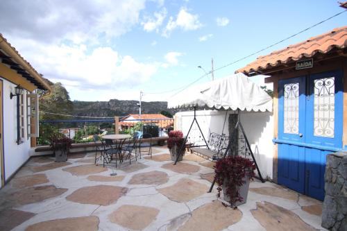 un patio con mesa y sillas en un edificio en Pousada Relíquias do Tempo, en Diamantina