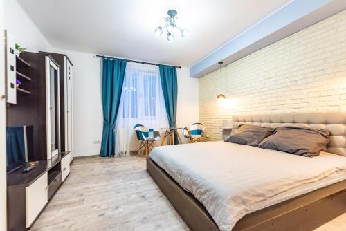 a bedroom with a large bed and a brick wall at Central Garden Apartments in Sibiu