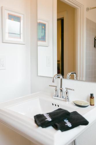 Un baño blanco con lavabo y espejo. en Les Cactus, en Palm Springs