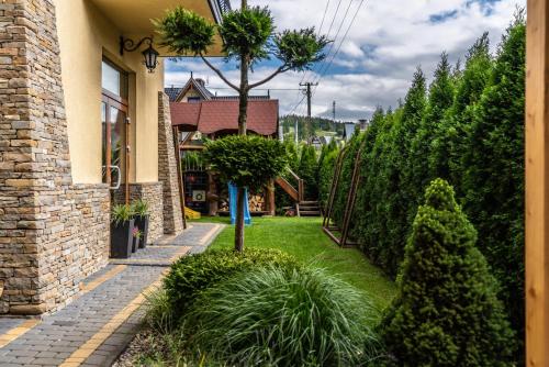a garden outside a house with trees and grass at Dunajecki Dworek in Zakopane