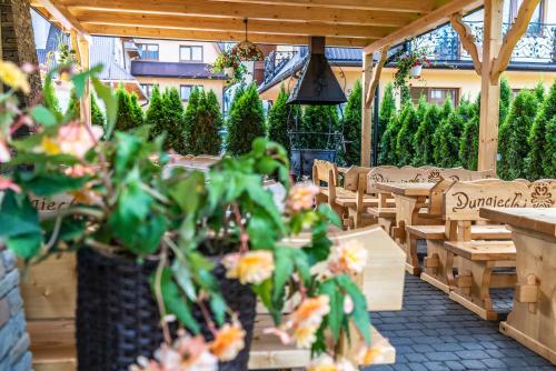 a patio with tables and chairs and a plant at Dunajecki Dworek in Zakopane