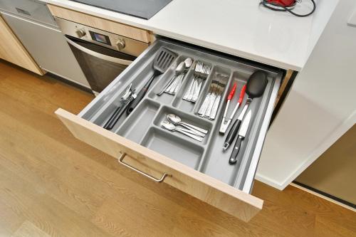 a drawer in a kitchen with utensils in it at Salisbury Style - Modern city apartment - Christchurch Holiday Homes in Christchurch