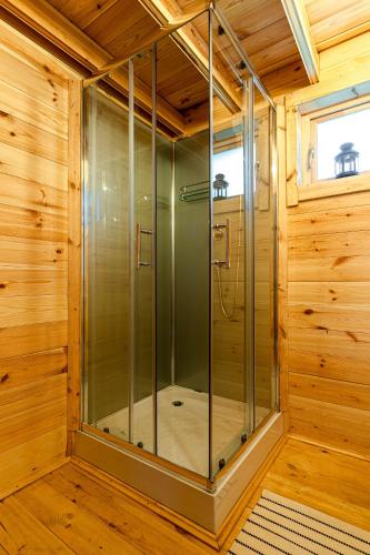 a sauna with a glass shower in a wooden room at Leśna Osada przy Suntago Park in Krzyżówka