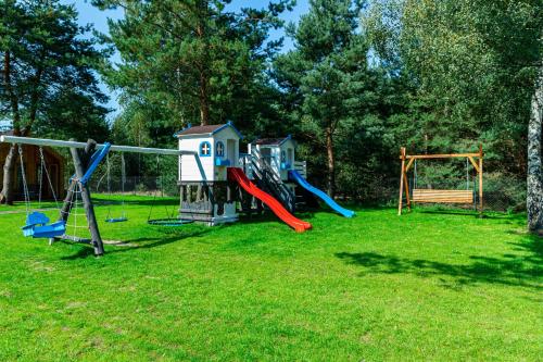 a group of playground equipment in a yard at Leśna Osada przy Suntago Park in Krzyżówka