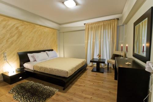 ein Schlafzimmer mit einem Bett, einem Schreibtisch und einem Sofa in der Unterkunft Iberis Hotel in Siátista