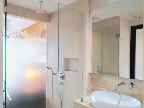 a bathroom with a sink and a glass shower at The Batu Hotel & Villas in Batu