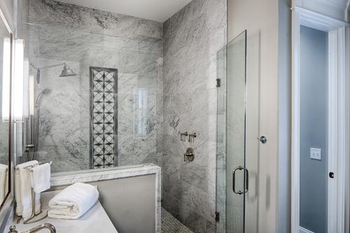 a bathroom with a shower and a sink and a tub at Liberty Street Redbrick Town and Carriage House in Savannah
