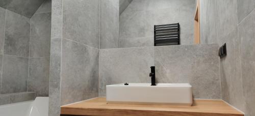 a bathroom with a white sink and a shower at Pensjonat Sztynort in Sztynort
