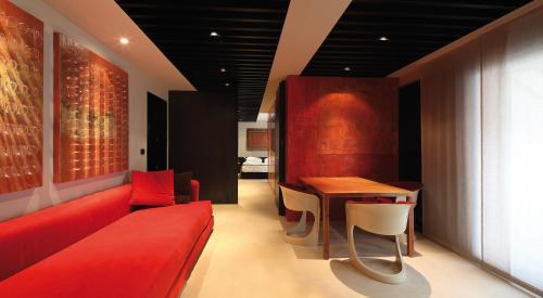 a living room with a red couch and a table at STRAF, Milan, a Member of Design Hotels in Milan