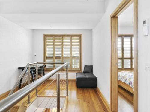 Habitación con escalera, cama y ventana en Driftwood Apartment Rye, en Rye