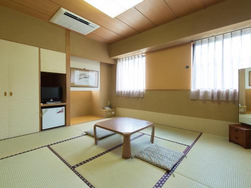 a living room with a table and a tv at Nagasaki Orion Hotel in Nagasaki