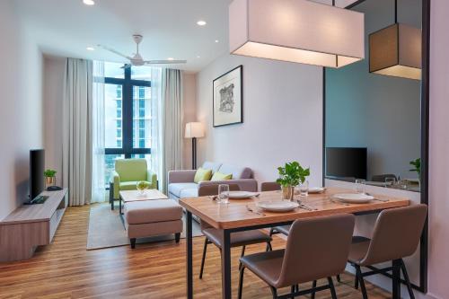 a dining room and living room with a table and chairs at Mercure Living Putrajaya in Putrajaya