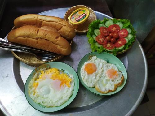 einen Tisch mit Eiern, Brot und Salat in der Unterkunft Ben's Home in Mai Châu