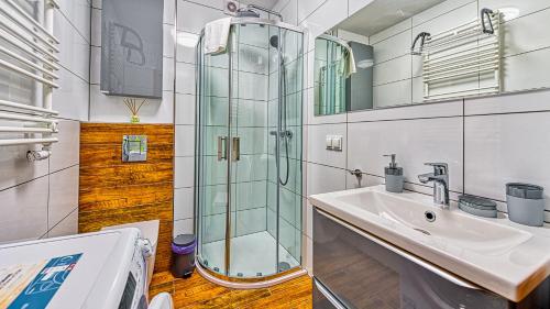 a bathroom with a glass shower and a sink at Apartament Studio Holiday Mountain Residence - 5D Apartamenty in Świeradów-Zdrój