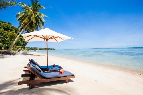 a beach with a chair and an umbrella and the ocean at Pao Jin Poon Villa in Lamai